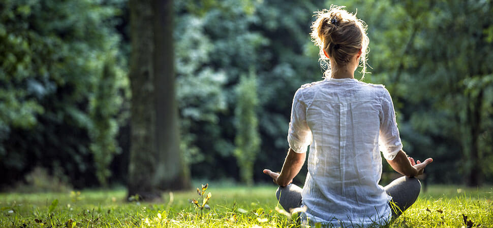 Meditáló nő a fűben, harmonikus élet és belső béke